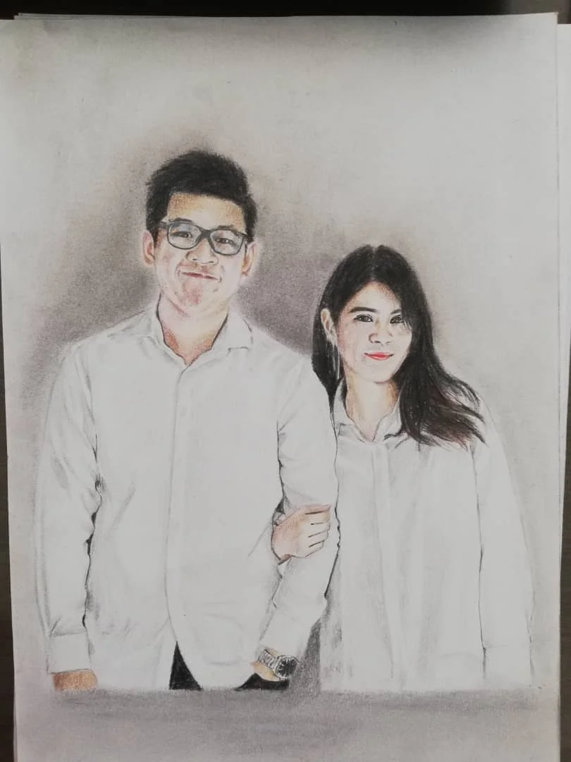 Hand-drawn portrait of a man and a woman standing together, both wearing white shirts. The man has short dark hair, glasses, and is smiling, while the woman has long dark hair and is also smiling. The background is plain.