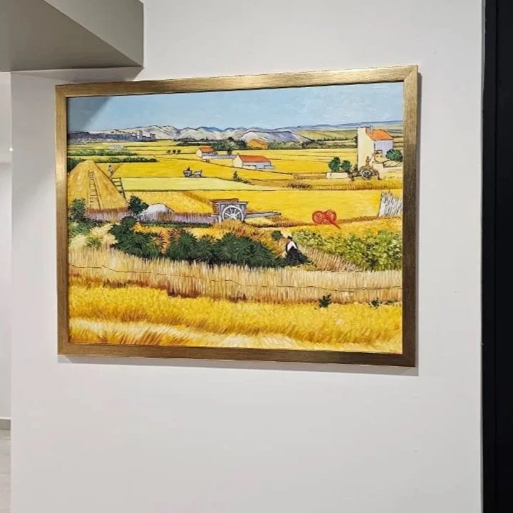 Painting of a rural landscape with fields, farmhouses, a haystack, and mountains in the distance.