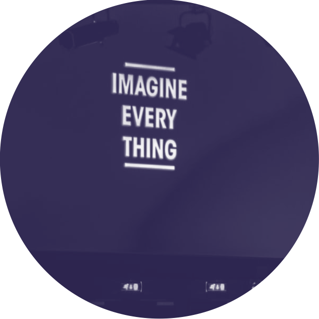 Panneau avec la citation 'Imagine Every Thing' en blanc sur fond sombre.