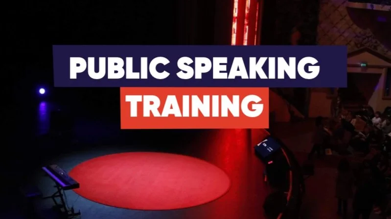 Affiche avec les mots 'Public Speaking Training' sur scène, plateau avec un tapis rouge, et une audience en arrière-plan.