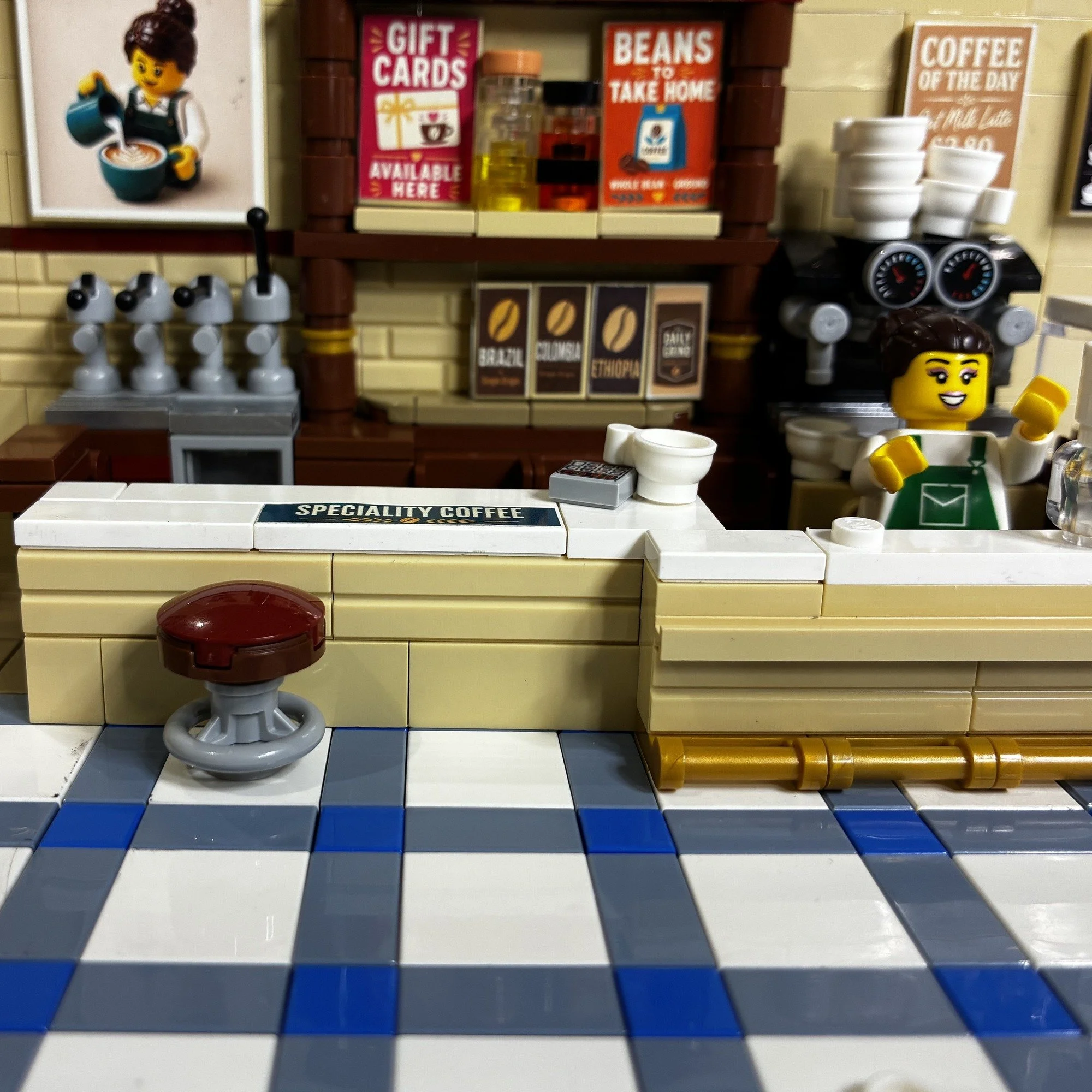The Daily Grind LEGO café MOC dressed with menu boards and coffee shop signage from the sheet.