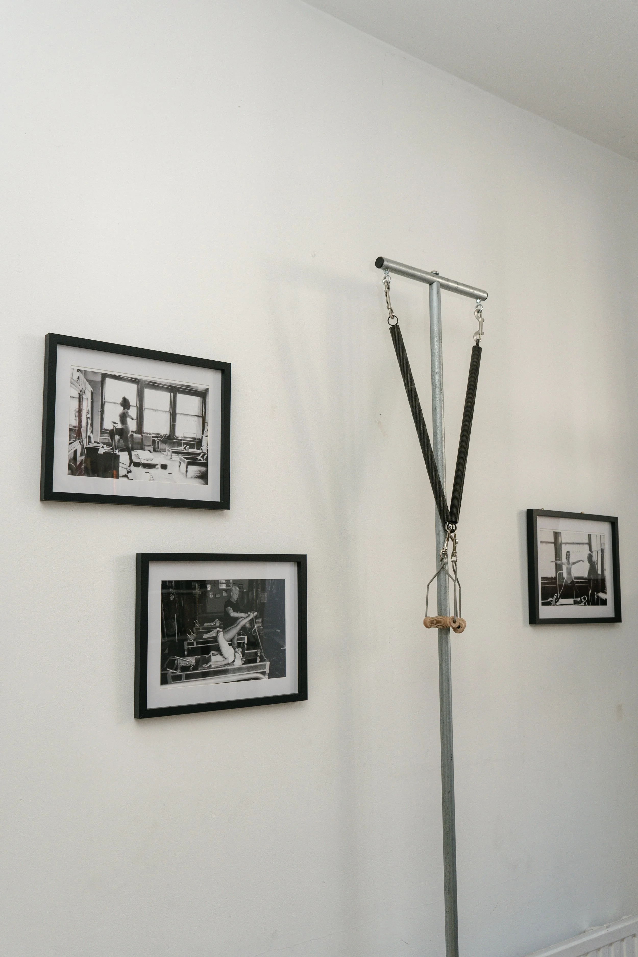 Classical Pilates apparatus and framed photographs inside the Chez Nous studio