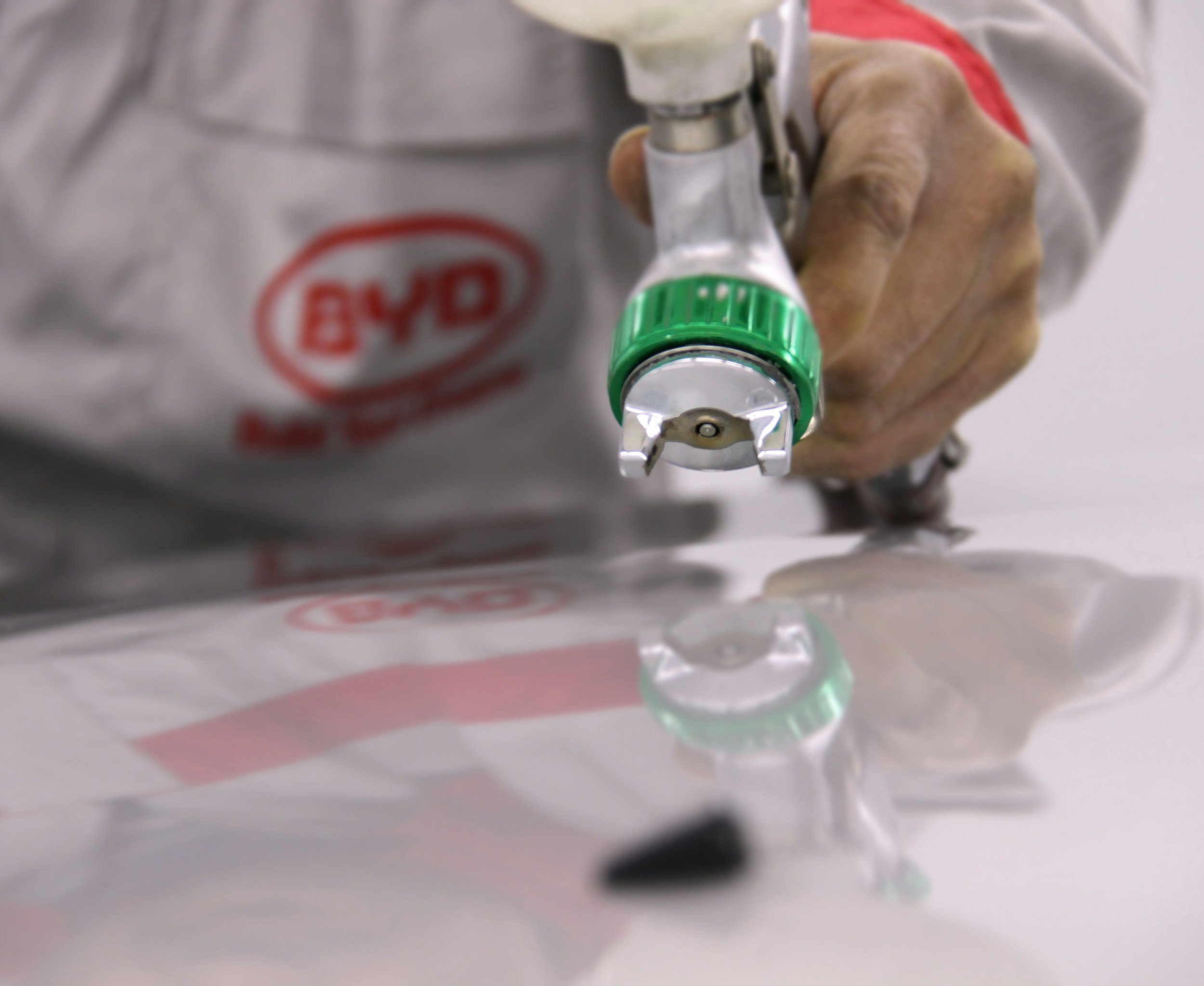 Close-up of a hand adjusting a valve on a medical oxygen tank, with the tank labeled 'OXYGEN' in red.