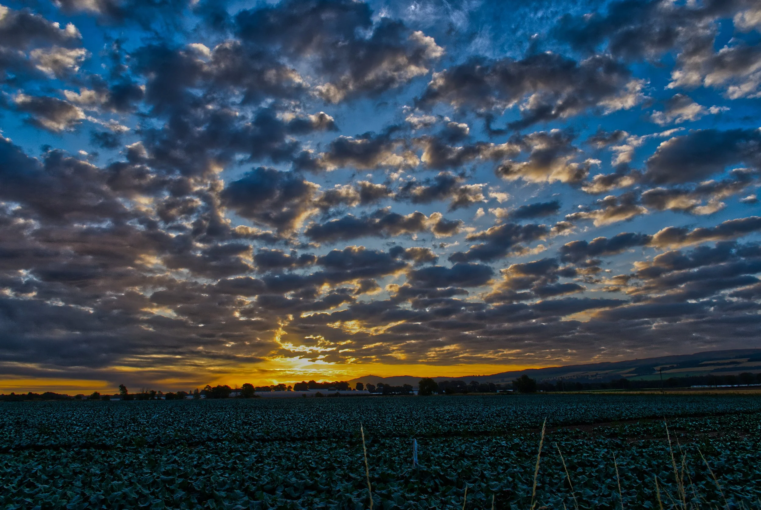 Fine art landscape print capturing a dramatic Scottish sunrise bursting through textured clouds.