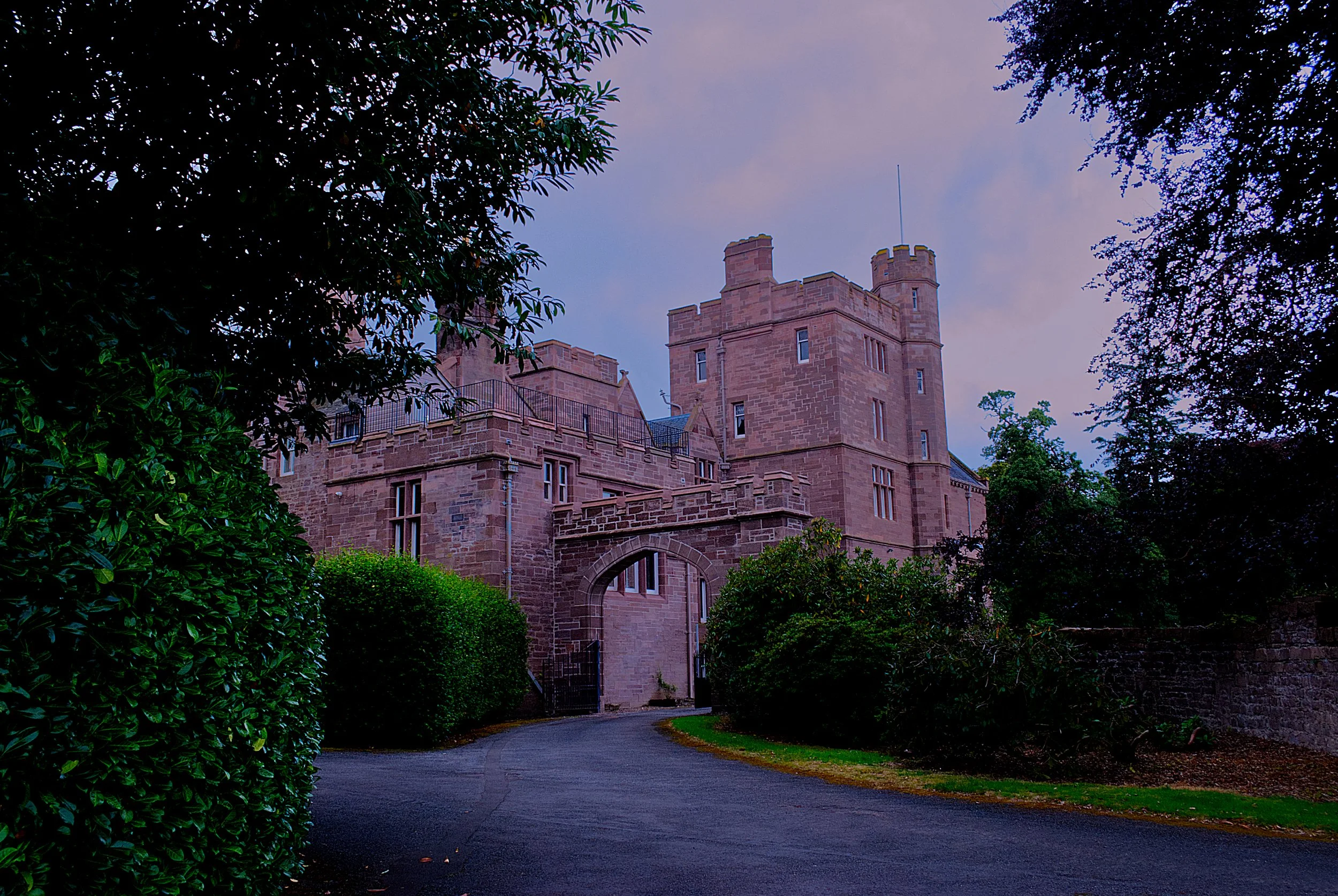Dramatic Scottish castle landscape print featuring a historic stone manor at sunset.