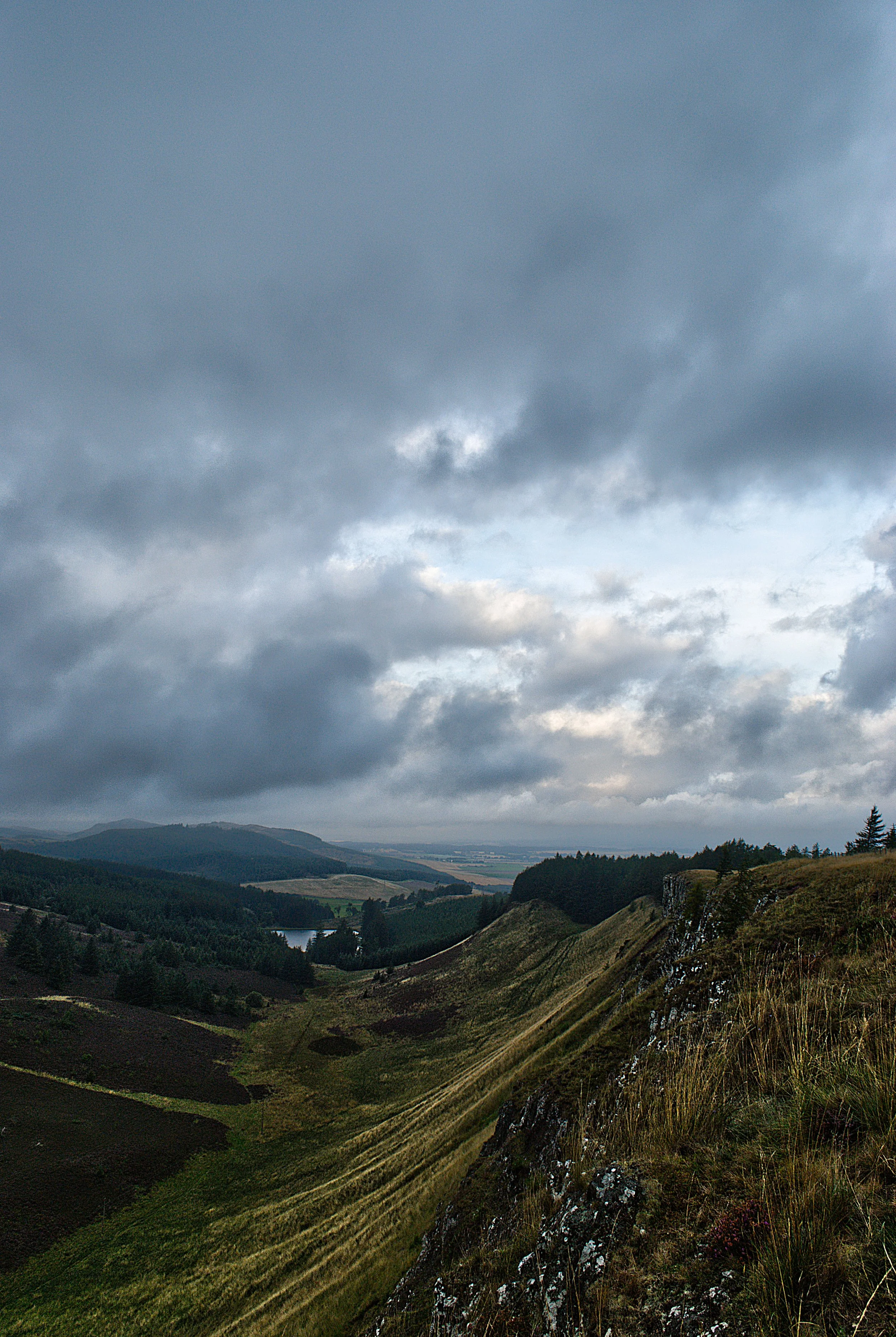 High overview photography capturing a misty valley and fishing loch in the East of Scotland.