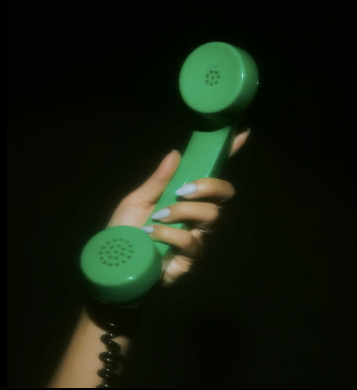 Hand holding a bright green telephone handset