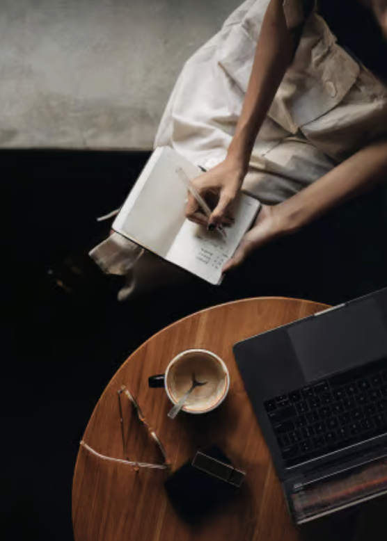 Person reading beside a cup of coffee