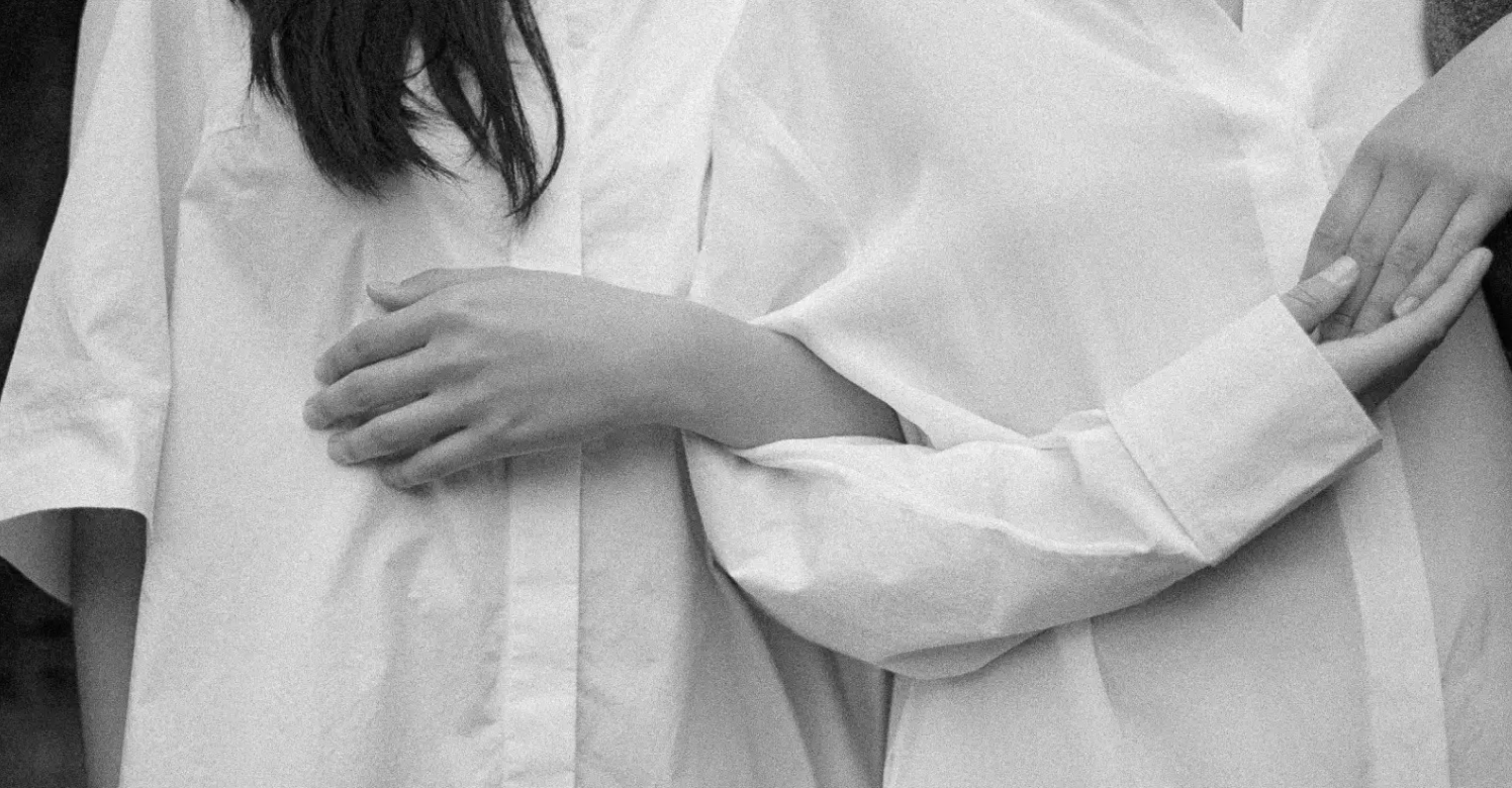 Black-and-white photo of a person resting a hand on their chest