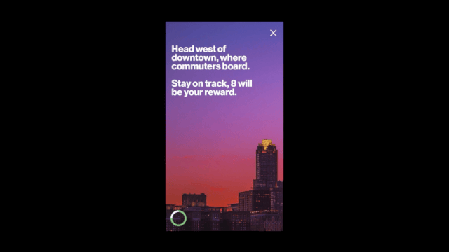 Mobile device screen showing a route suggestion to head west of downtown, with a city skyline at sunset in the background.