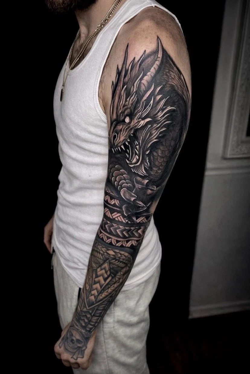 Black and gray tattoo sleeve featuring a fierce dragon's head with glowing eyes, intricate scales, and detailed patterns on a person's arm.