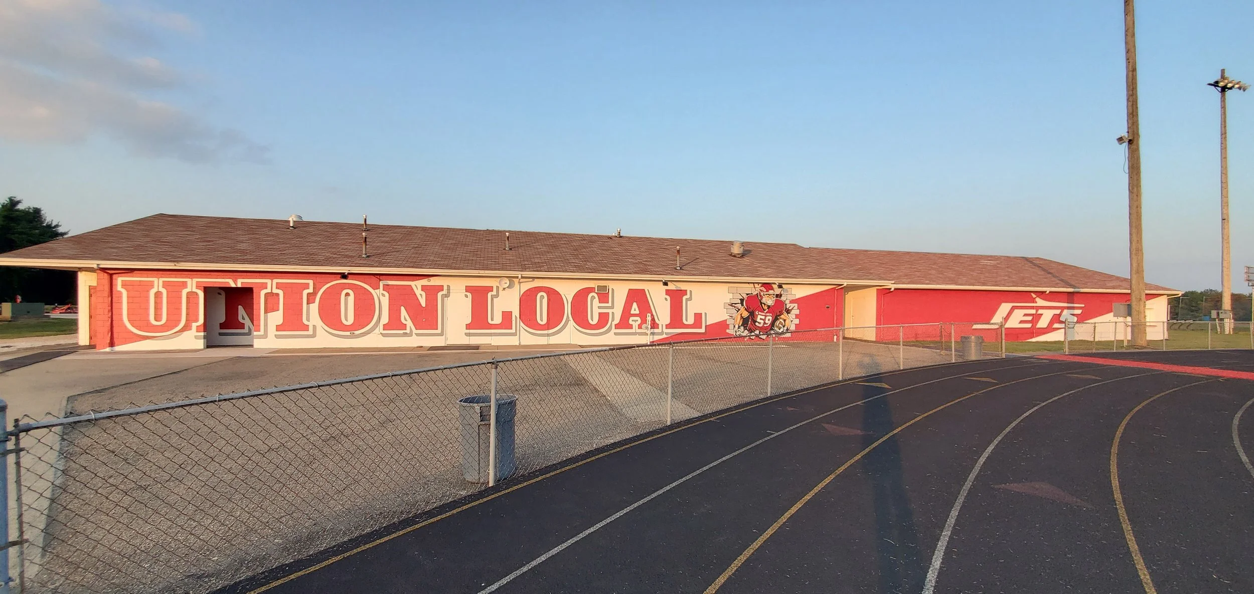 School building with a mural reading 'UNION LOCAL' and an illustration of a football player in uniform.