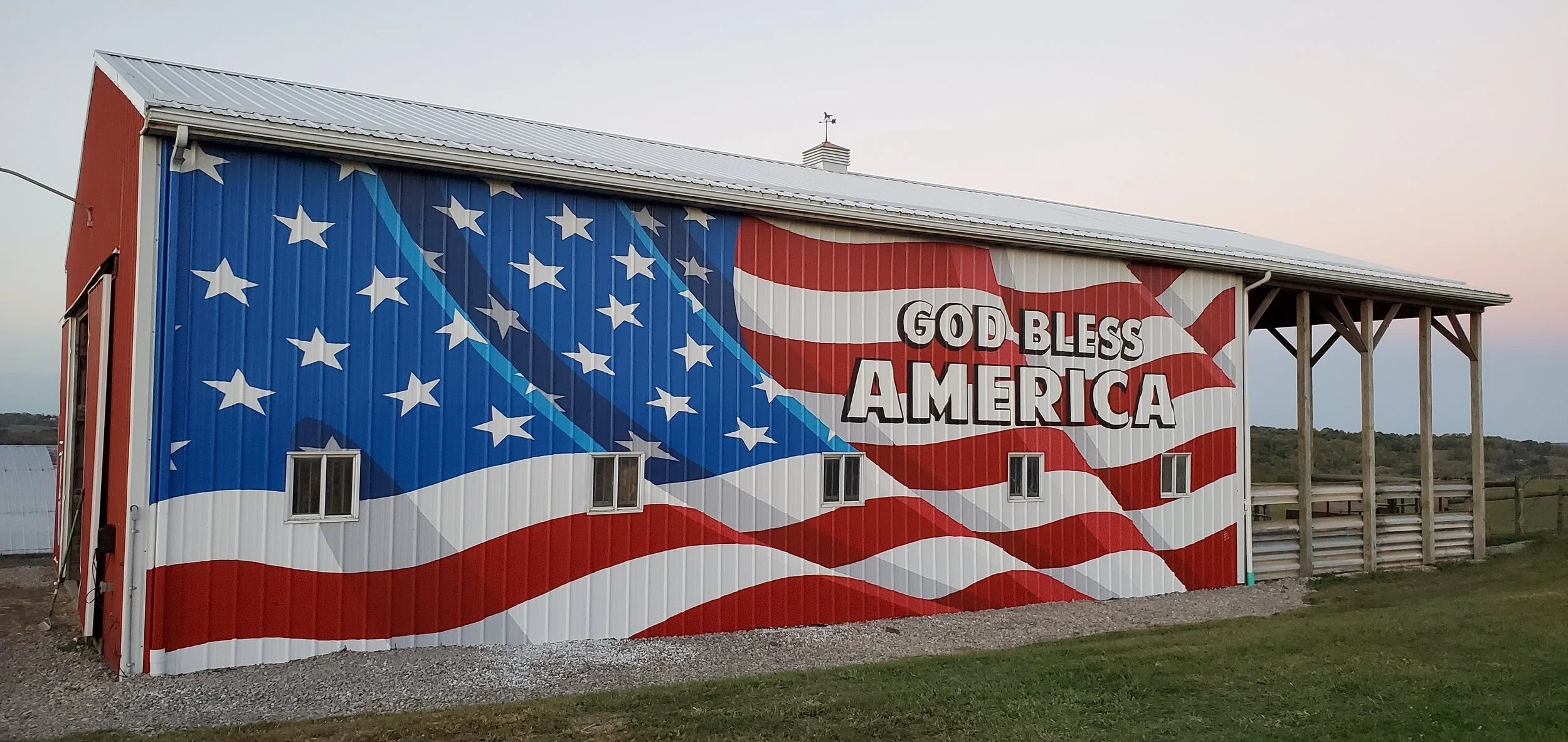 A building with a mural of the American flag and the words 'God Bless America' painted on it.