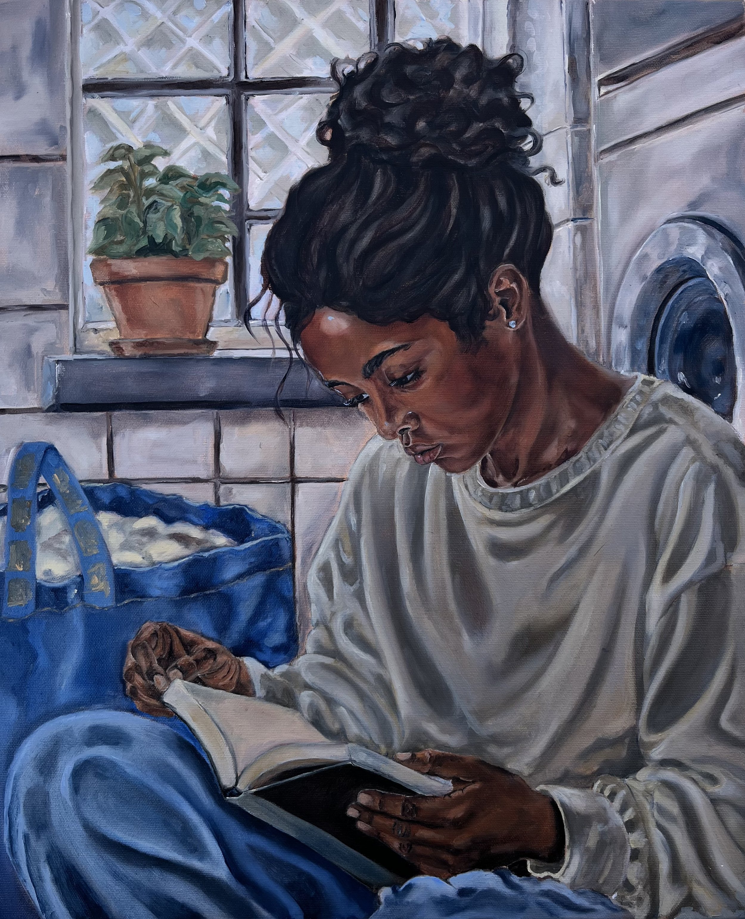 A woman with dark, curly hair styled in an updo and wearing pearl earrings is looking downward. She has a nose piercing and is wearing a light-colored top. The background shows a window with a flowerpot containing green plants, a brick wall, and a laundry machine.