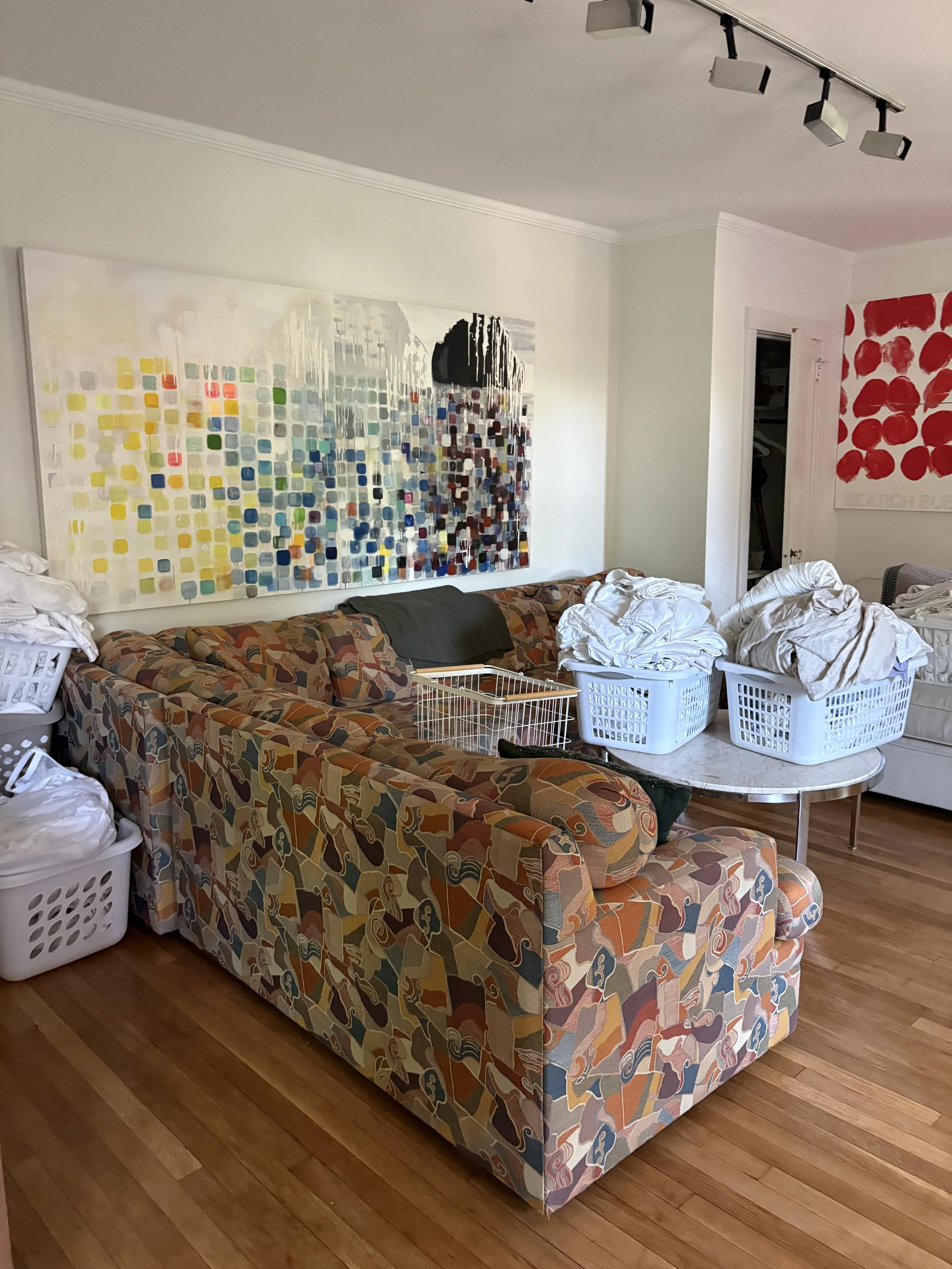Before: Main living room in one of the homes, an Airbnb. The art and upholstery competed and the space felt uncomfortable, and out of balance