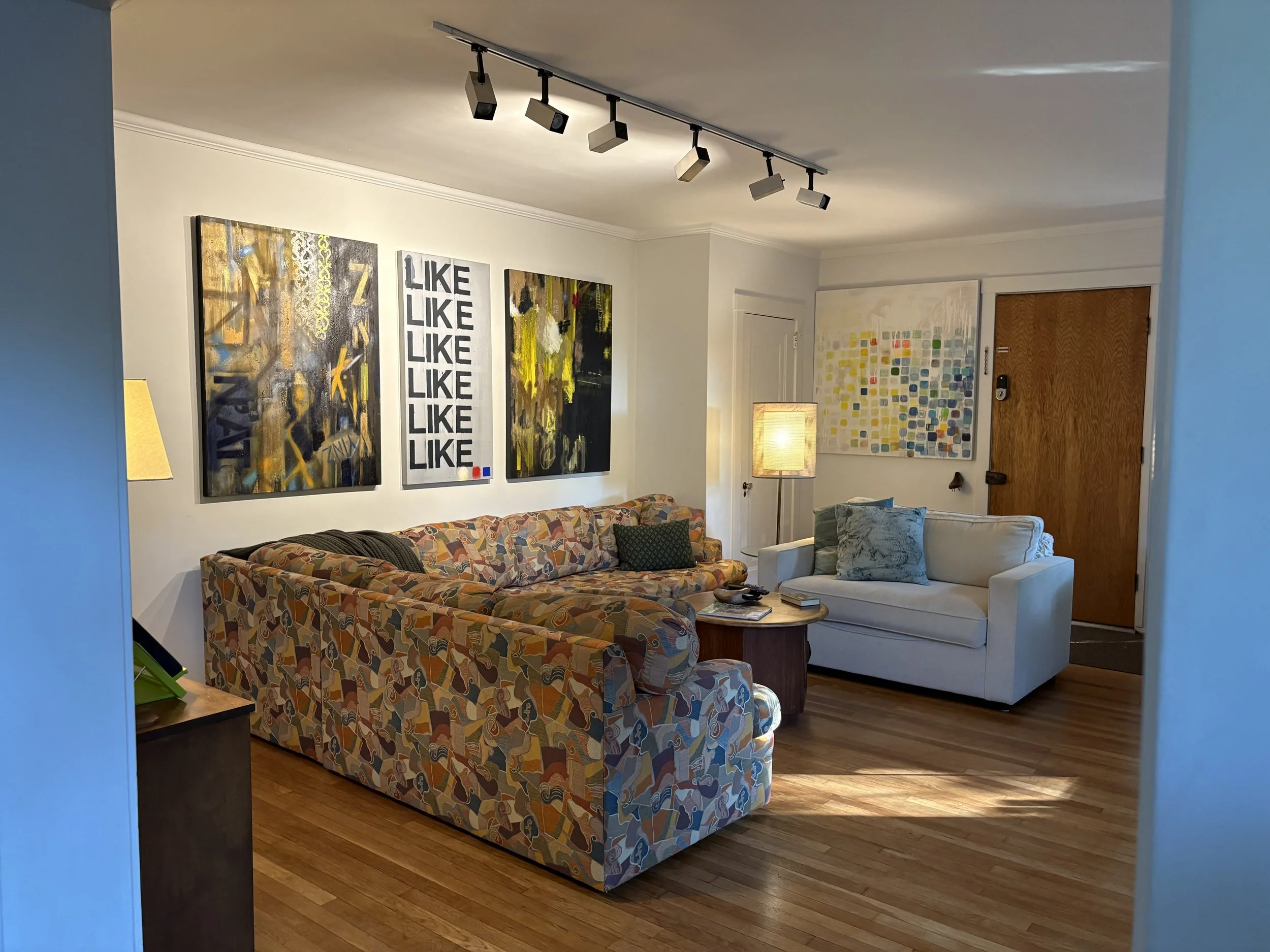 After: This is the main living space in one of the homes. The heavily patterned couch needed art that would help balance it, and create some calm in this busy, whimsical space