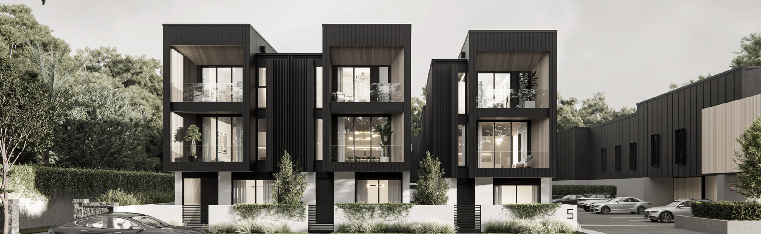 Modern multi-story residential building with black and wood exterior, large glass windows and balconies, surrounded by trees and a parking lot with several cars.
