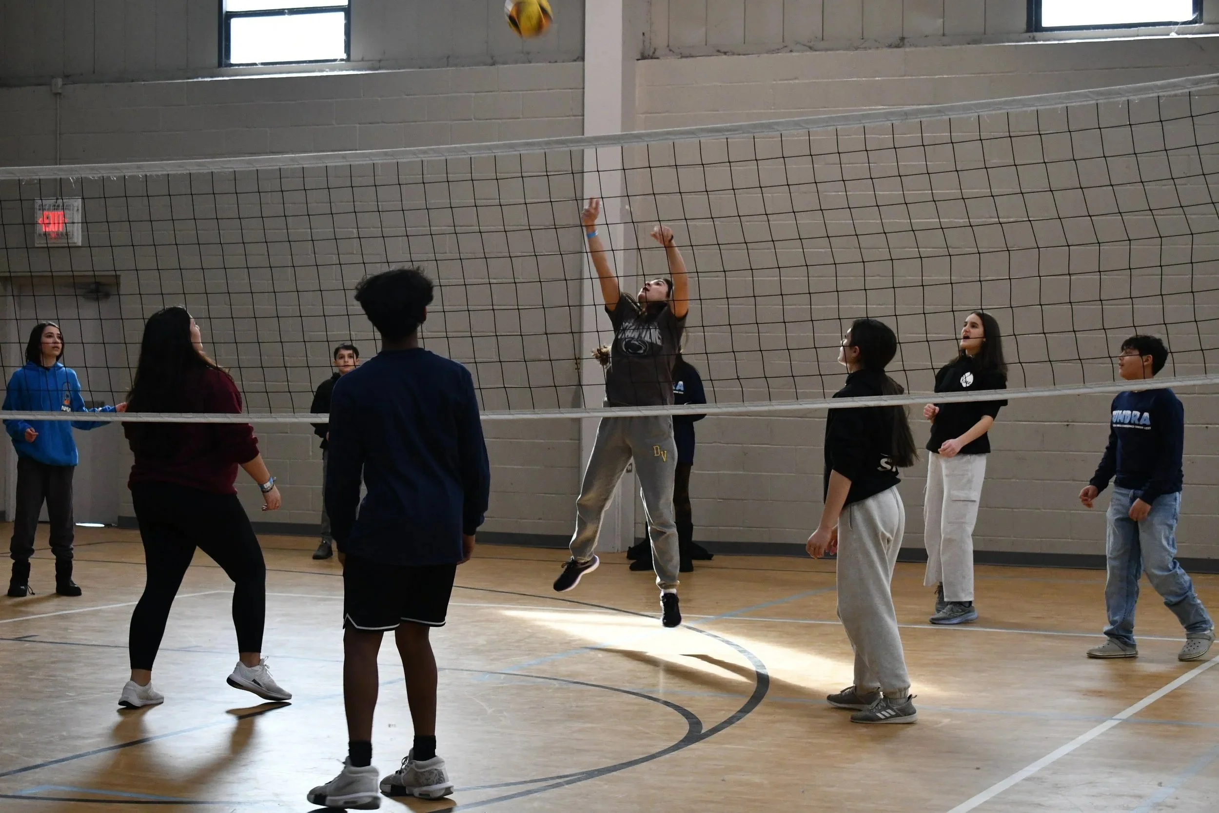 A group of teenagers playing volleyball.