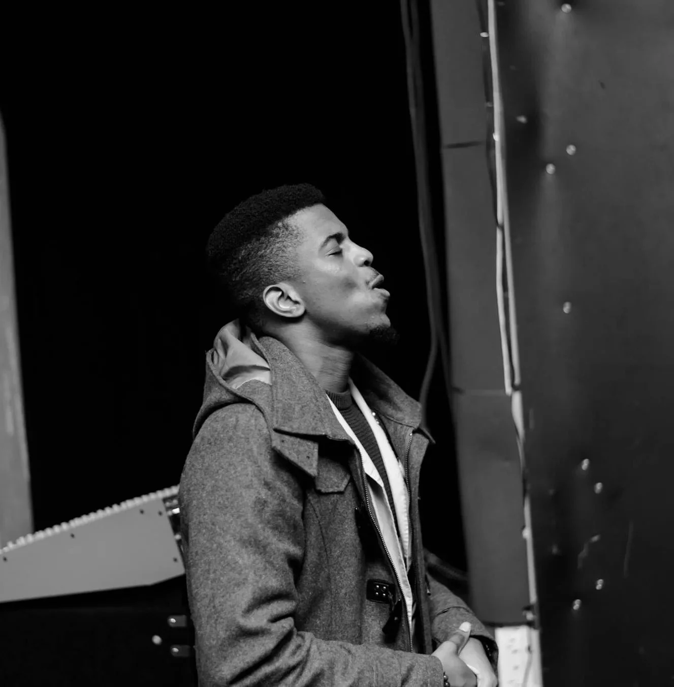 A black and white image of a young man praying.