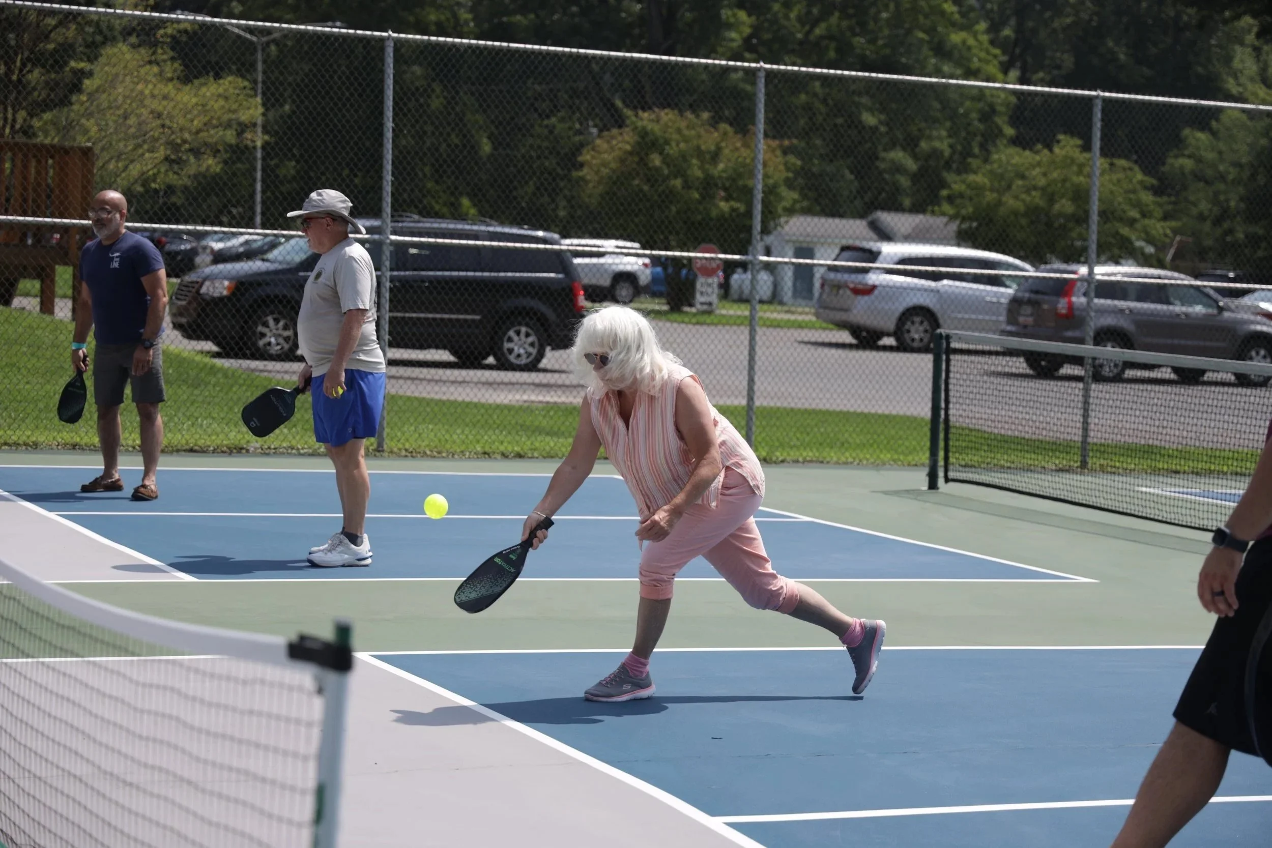 A few elderly adults playing tennis.