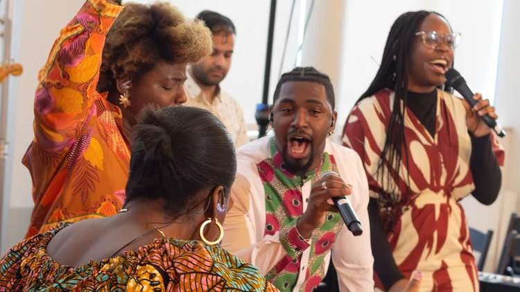 Members of Ignite Church's worship team singing and dancing on stage.