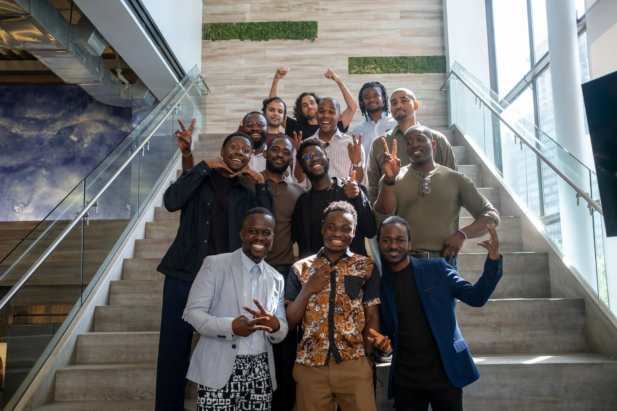 A group of Anchor Men members posing on a staircase, smiling at the camera.