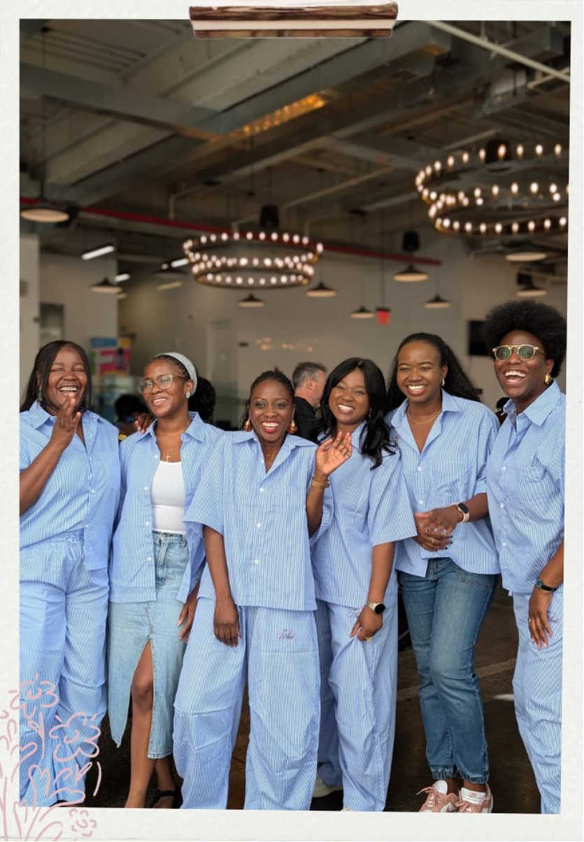 A groups of six Ignite Sisterhood members wearing Sisterhood merch, smiling and posing for the camera.