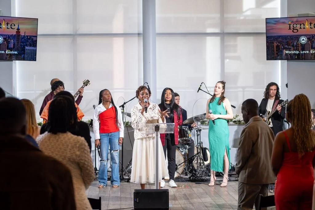 The Ignite Church worship team and Pastor Bukky standing on stage.