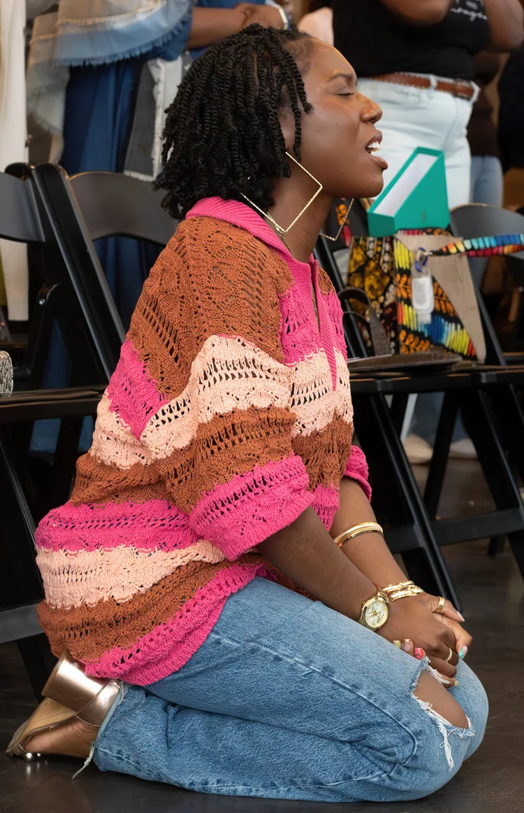 A young woman kneeling in worship.