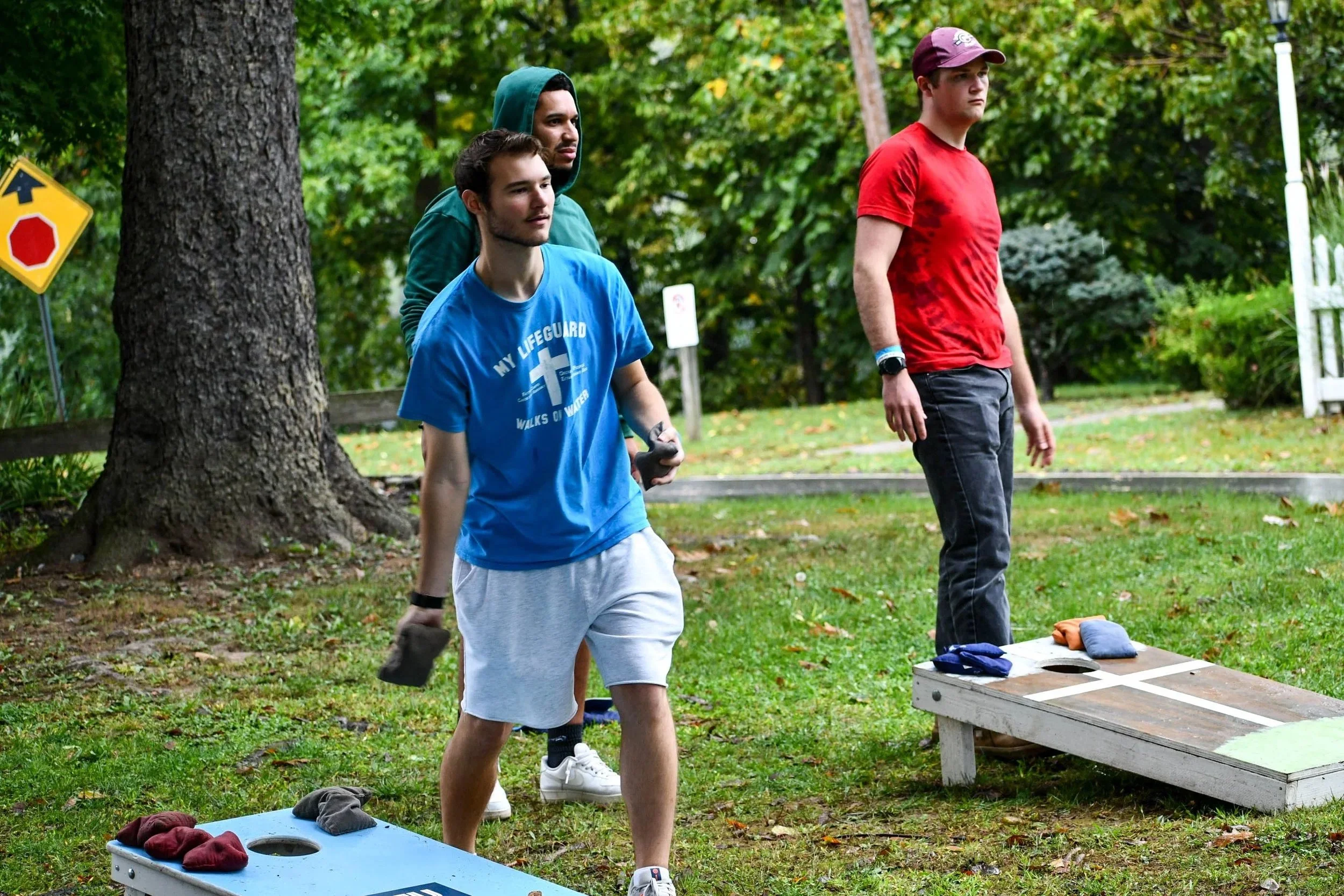 A group of adults playing bean bag toss.
