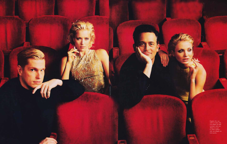Four people sitting in red theater seats, two women and two men, all dressed formally.