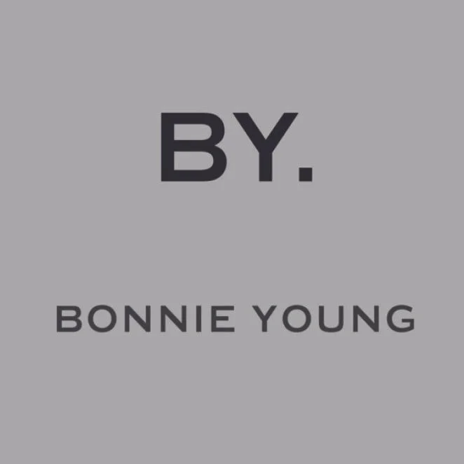 Book cover with gray background, the title 'BY.' in large black letters, and the author's name 'BONNIE YOUNG' in smaller black letters.