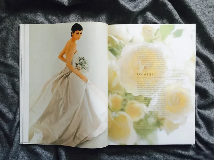 Open magazine spread featuring a woman in a wedding dress on the left page and a floral background with text on the right page.