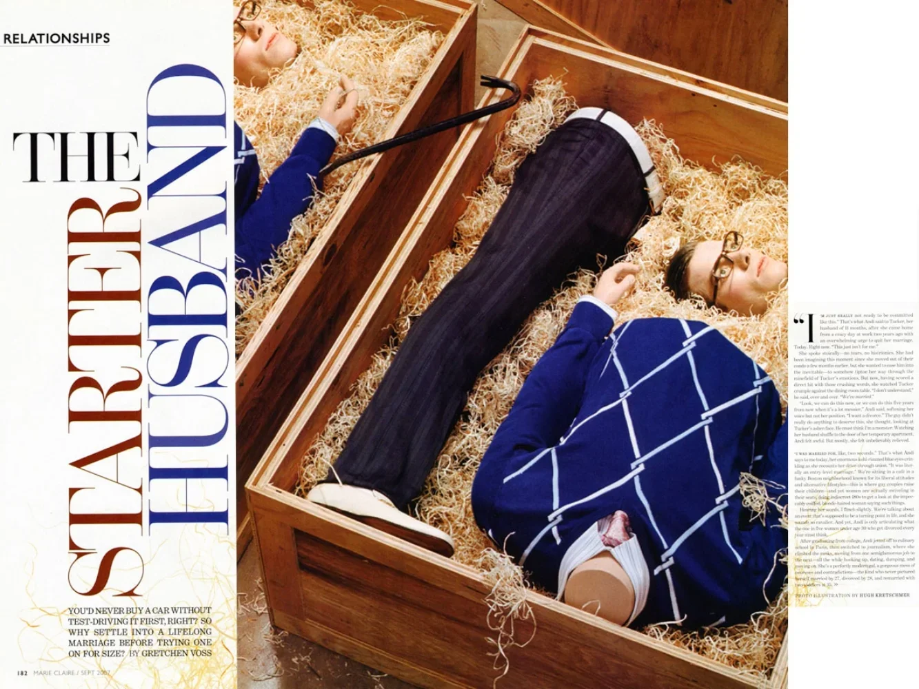 Two women lie in wooden boxes filled with straw, dressed in blue and white clothing, with one wearing glasses.