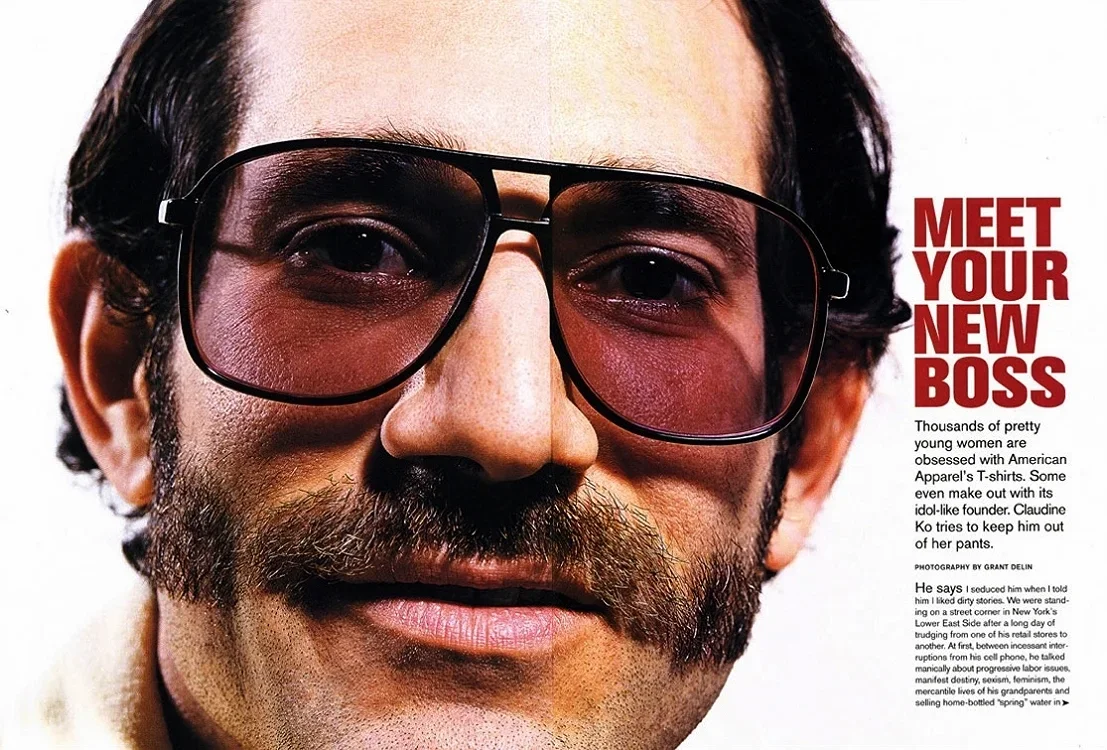 Close-up of a man with dark hair, a mustache, beard, glasses with a pink tint, and a slight smile, next to an article titled "Meet Your New Boss".