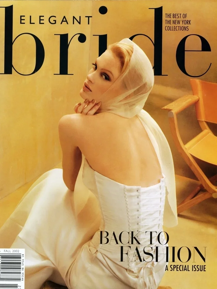 Magazine cover titled "Elegant Bride" featuring a woman in a white strapless wedding dress with a corset back and a sheer veil covering her head, seated against a yellowish background with orange chairs nearby.