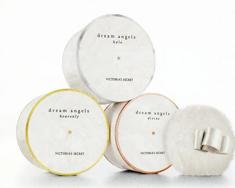 Four Victoria's Secret Dream Angels body powders in round containers labeled Heavenly, Halo, Divine, and one with a ribbon on the lid.