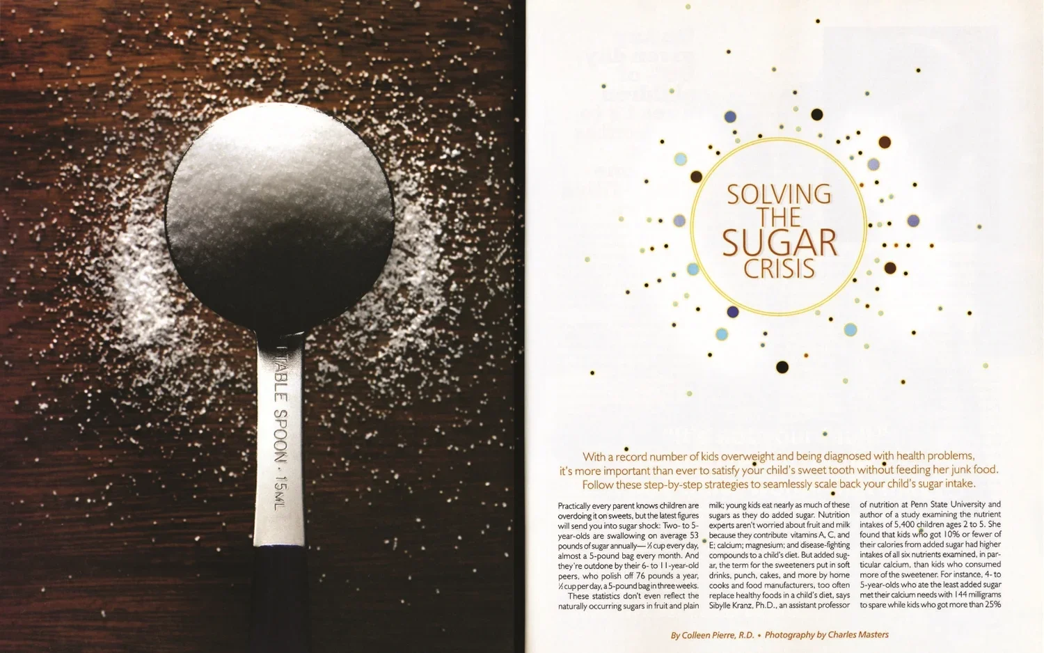 A spoon with the words "TABLE SPOON .15ML" engraved on it, placed on a wooden surface surrounded by scattered white powder, likely sugar.