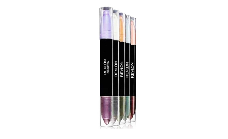 Four colorful Revlon jumbo eye shadow sticks standing upright with black labels and clear caps.
