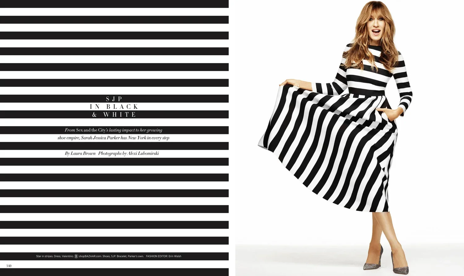 A woman in a black and white striped dress holding a part of her skirt, standing with one leg crossed over the other against a white background.