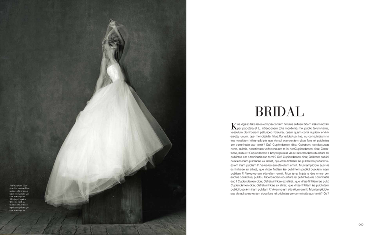 Black and white photo of a wedding dress on a mannequin against a dark background.