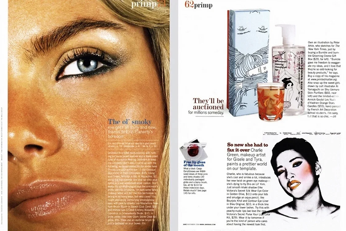 A magazine open to a two-page spread, featuring close-up photography of a woman's face with detailed skin texture, eye makeup, and a visible eye. The page contains various beauty and cosmetic products, including a lipstick, lip gloss, and a complex i
