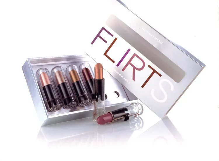 A makeup set with six lipstick tubes, some with caps removed, and the box labeled 'FLIRT'S' with an opening showing the contents inside.