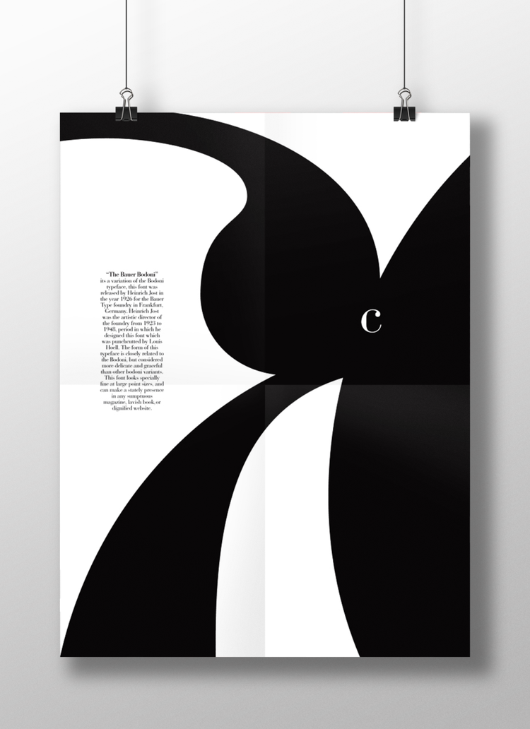 A black and white poster with large abstract shapes and a small paragraph of text on the left, hanging from two clips.