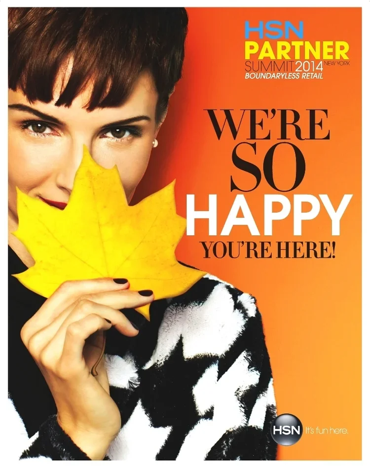 A woman with short dark hair holding a large yellow autumn leaf in front of her face, smiling and looking directly at the camera. The background is orange, and the image includes promotional text for HSN Partnership Summit 2014 with the message "We'r