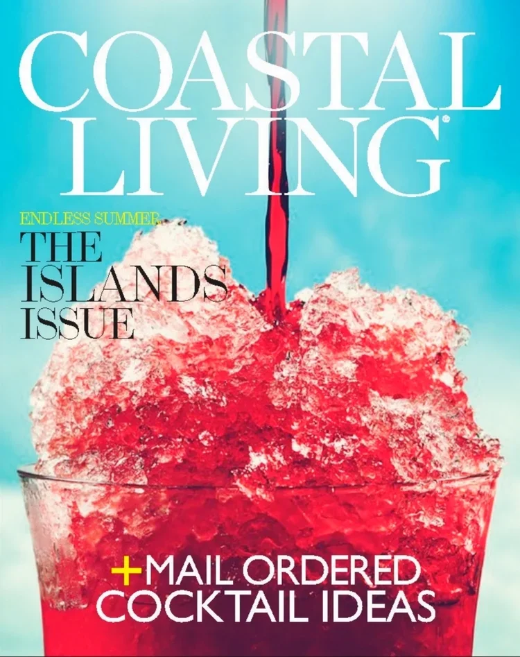 Close-up of a magazine cover titled 'Coastal Living' featuring a glass filled with crushed ice and red liquid, with the juice being poured into the glass.