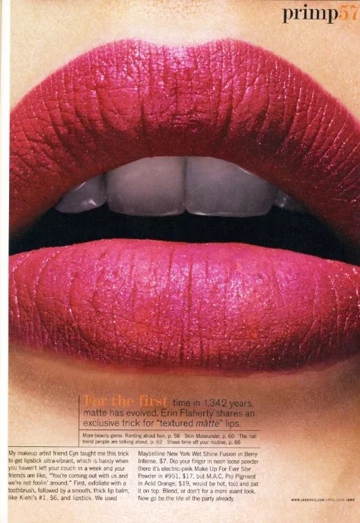 Close-up of lips with pink lipstick and partially visible teeth.