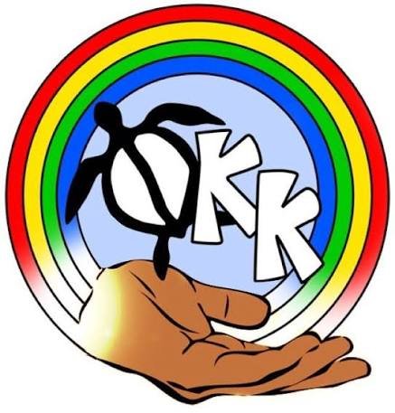 A hand holding a rainbow-colored circle with the words 'OK' and 'K' inside, against a light blue background.