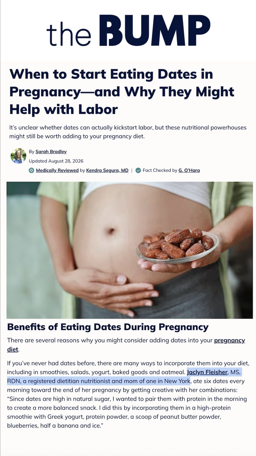 A pregnant woman is holding a small bowl of dates in front of her belly, with her other hand resting on her abdomen.