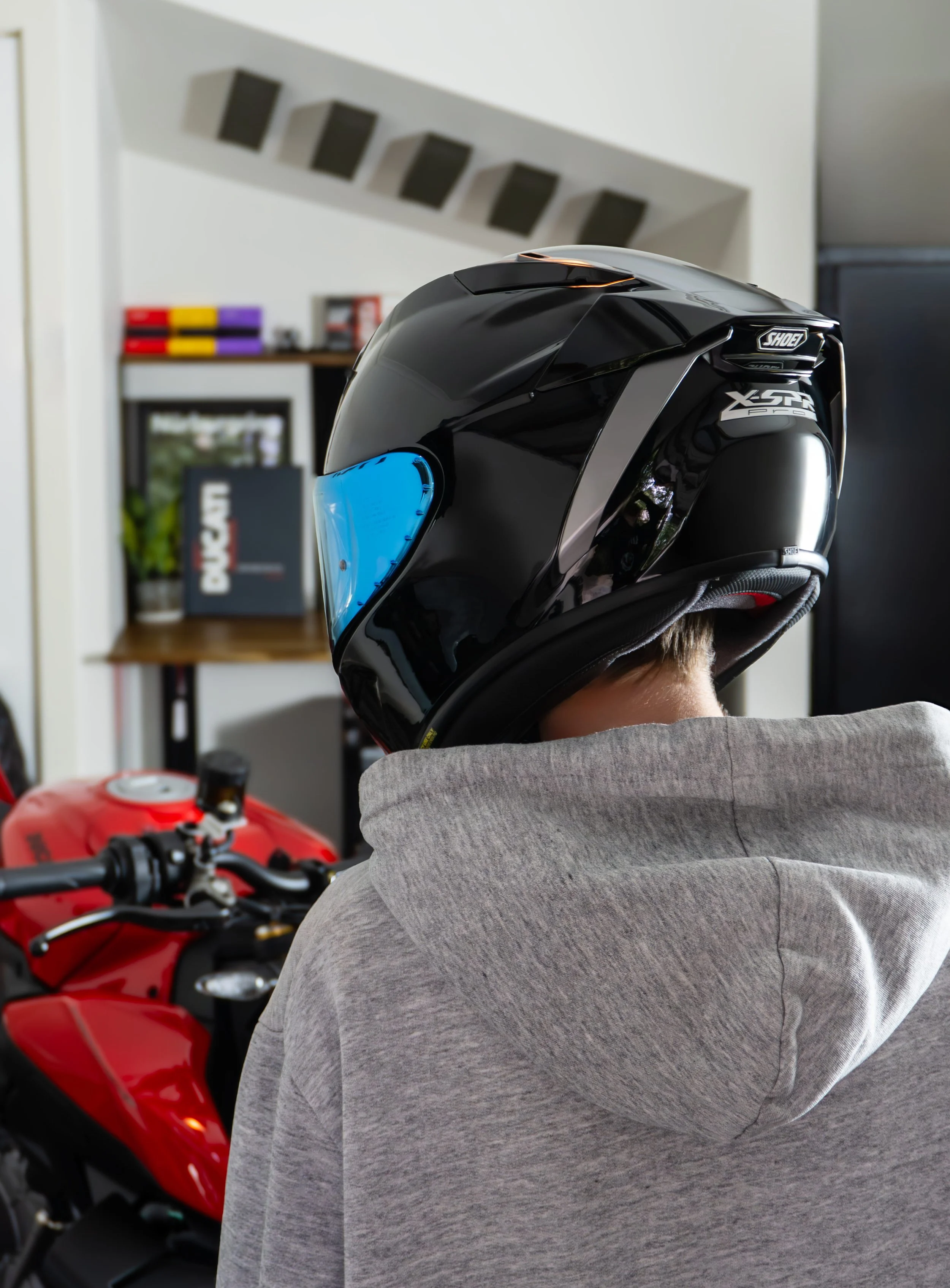 Person wearing a black Shoei helmet with a blue visor after completion of the helmet package at a motorcycle detailing studio in Cheltenham, Melbourne.
